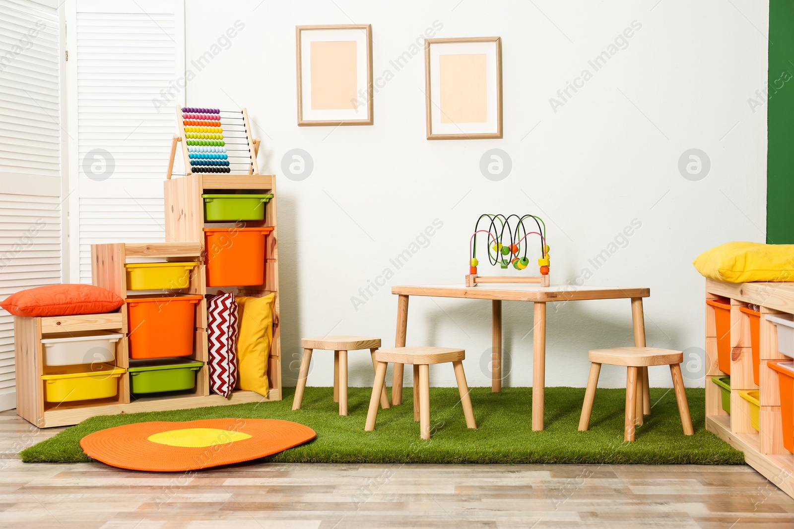 Photo of Stylish playroom interior with table and stools