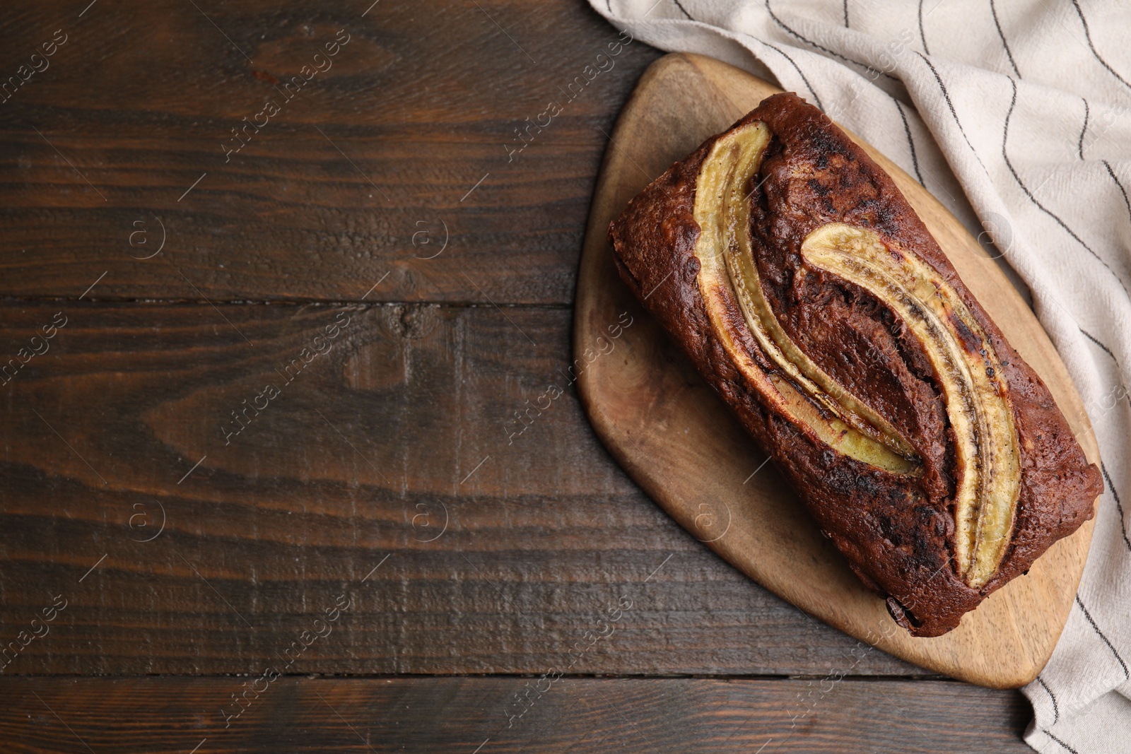 Photo of Delicious banana bread on wooden table, top view. Space for text