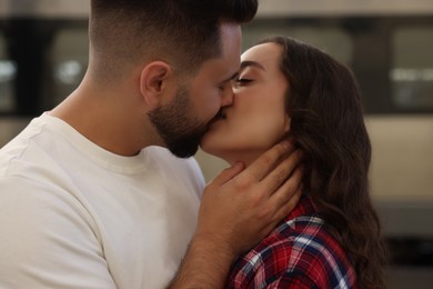 Long-distance relationship. Beautiful couple kissing near train outdoors