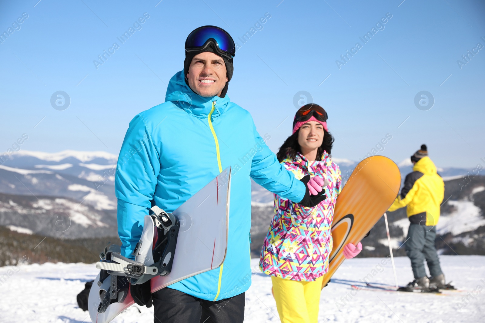 Photo of Couple with snowboards at ski resort. Winter vacation