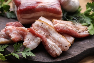 Photo of Pork fatback and fresh parsley on wooden table, closeup