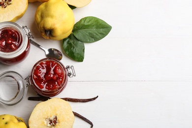 Delicious quince jam and fruits on white wooden table, flat lay. Space for text