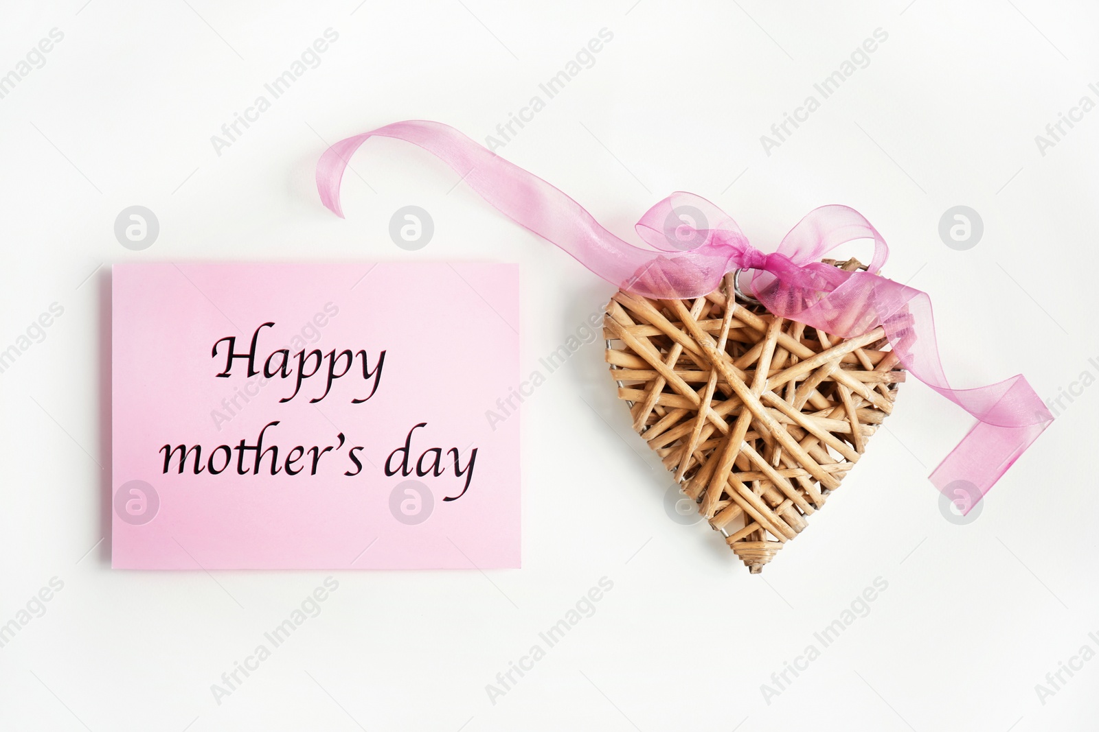 Photo of Card with words "Happy Mother's day" and wicker heart figure on light background, top view