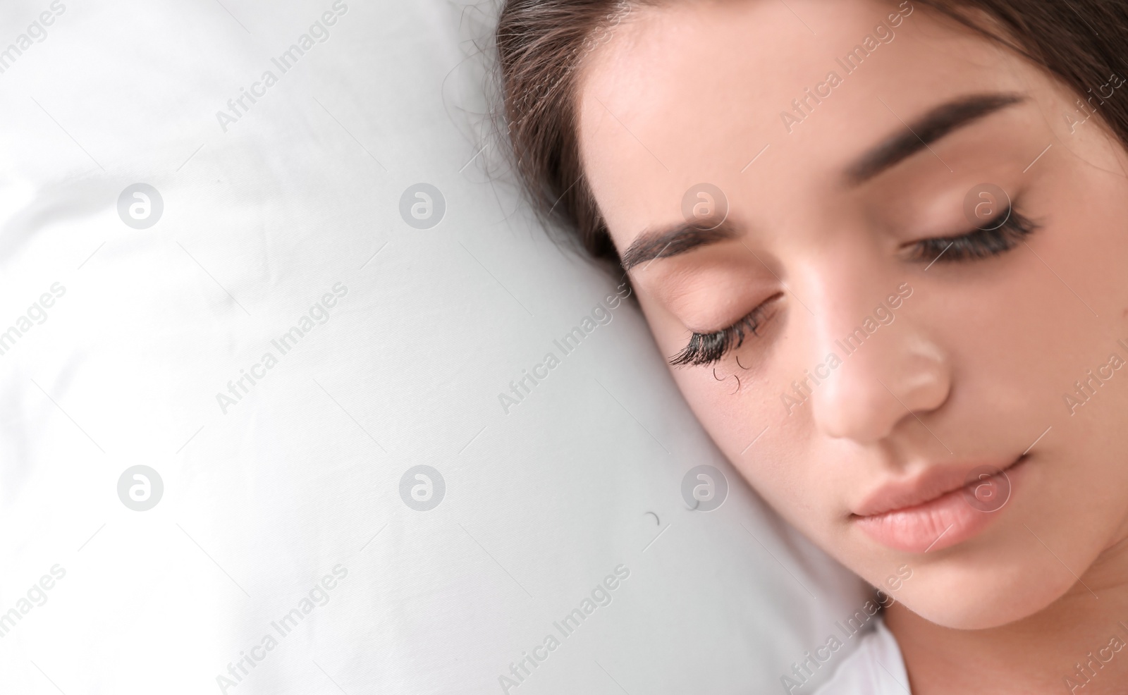 Photo of Young woman with eyelash loss problem sleeping in bed