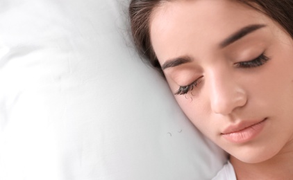 Photo of Young woman with eyelash loss problem sleeping in bed