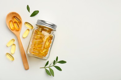 Bottle, vitamin capsules, spoon and leaves on white background, flat lay. Space for text