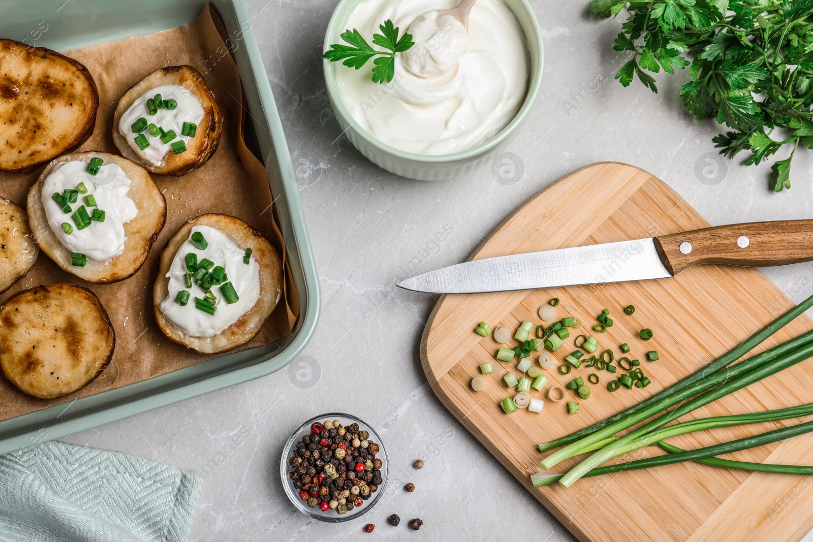 Photo of Sour cream dressing and delicious potato wedges on light grey table, flat lay