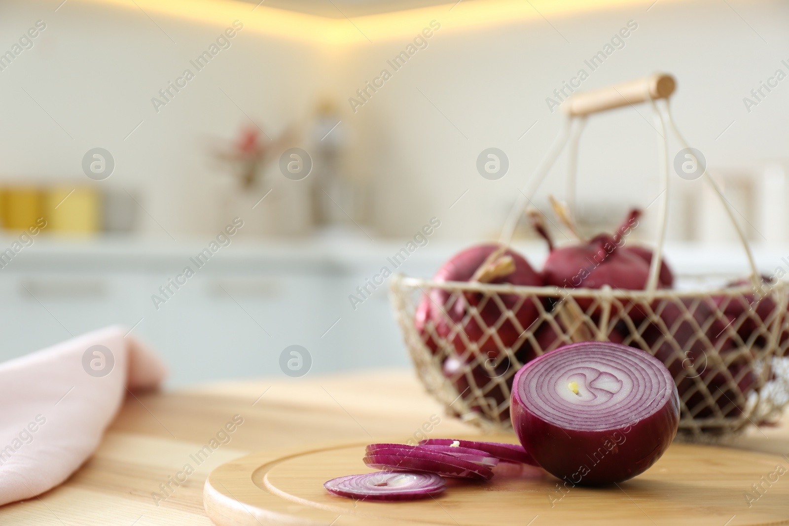 Photo of Cut red onion on wooden table in kitchen