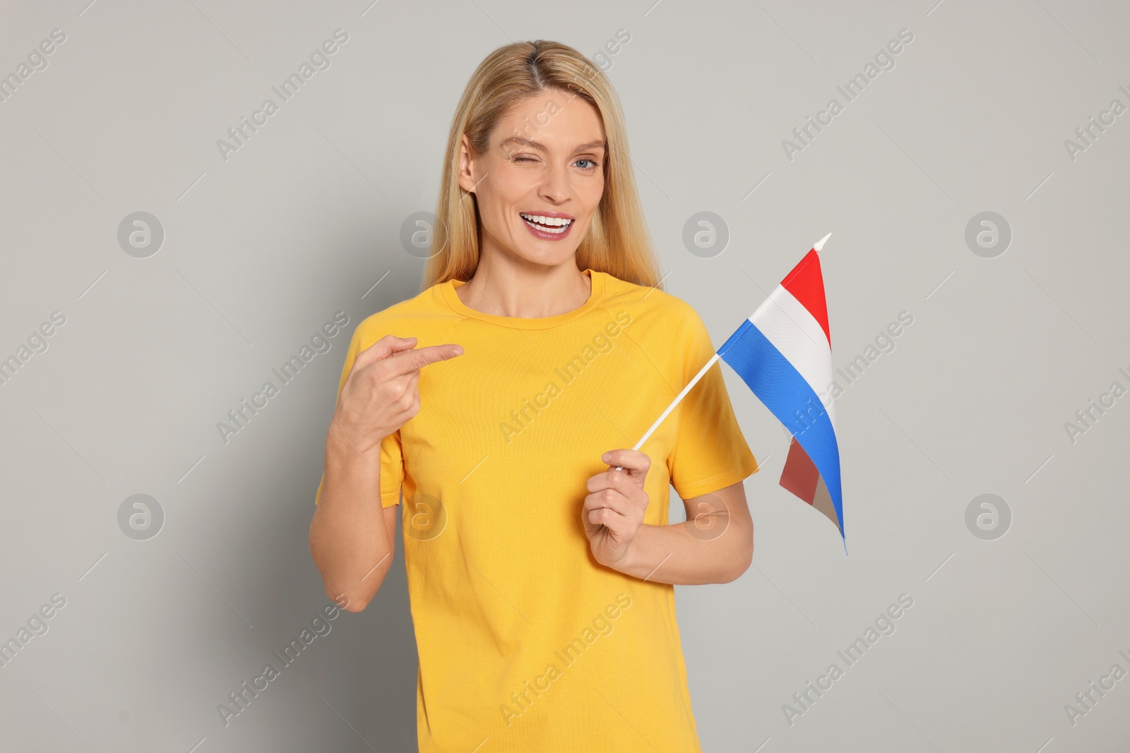 Photo of Woman with flag of Netherlands on light grey background