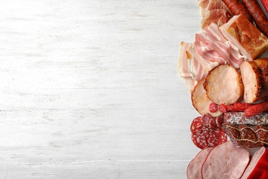 Photo of Flat lay composition with different meat delicacies and space for text on wooden background