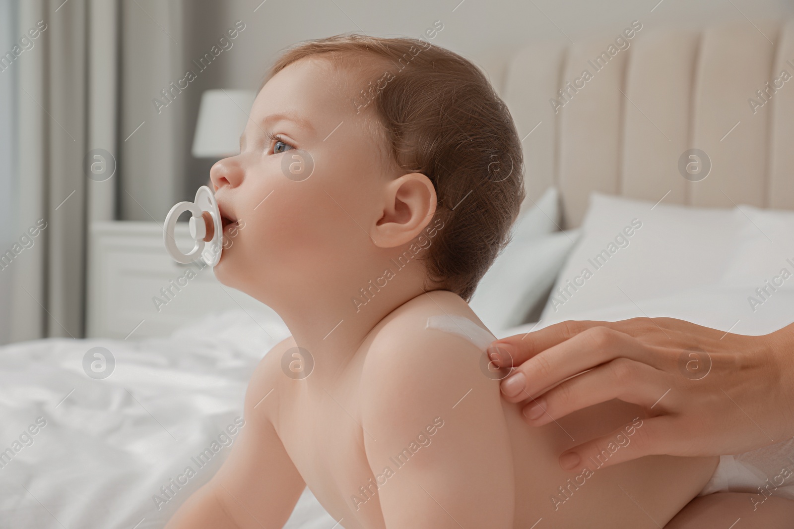 Photo of Mother applying cream on her little baby, closeup