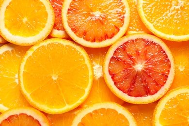 Slices of fresh citrus fruits as background, top view