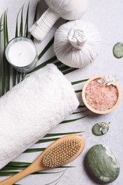 Photo of Flat lay composition with herbal massage bags and spa products on light grey table