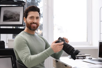 Photo of Professional photographer with digital camera at table in office