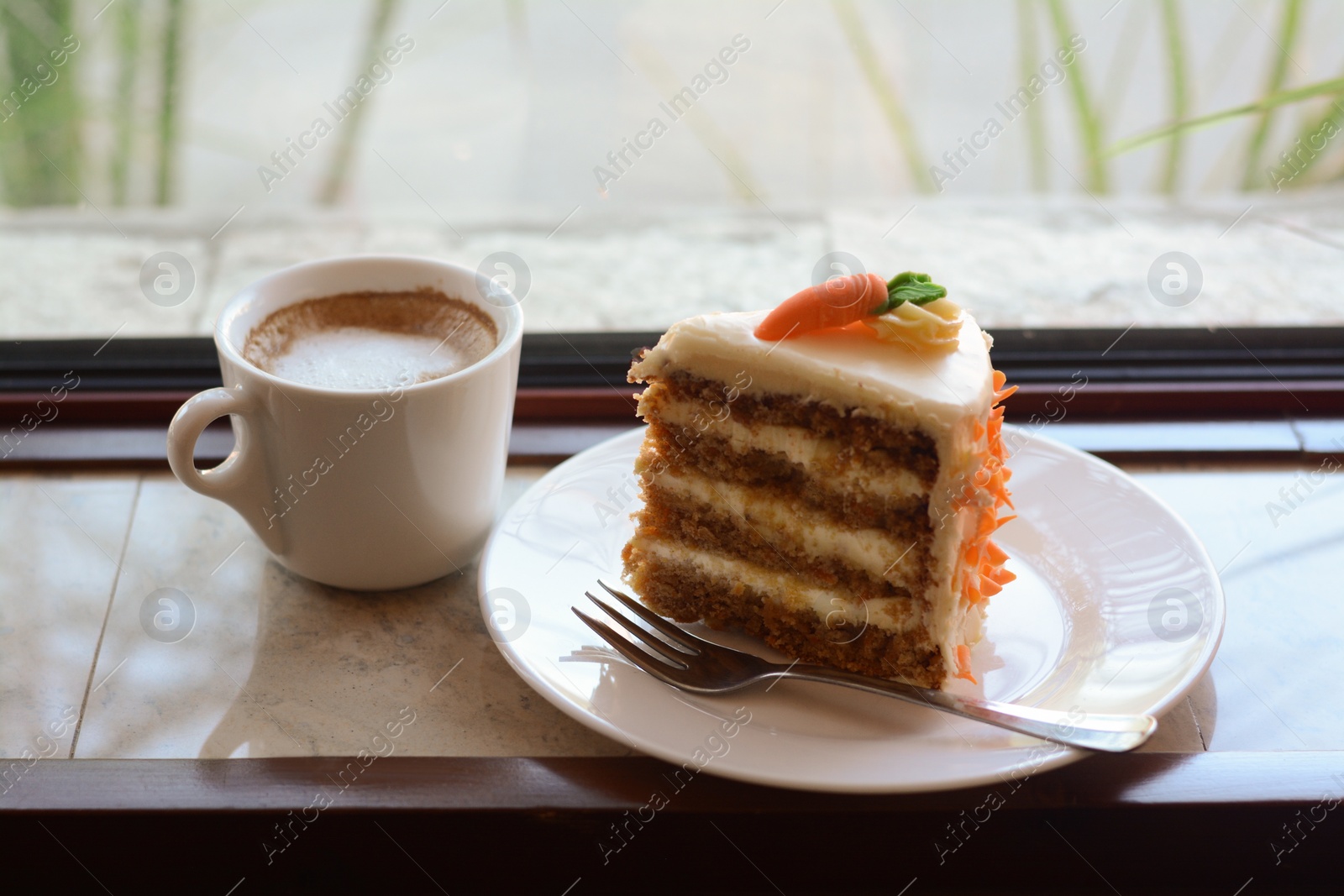 Photo of Delicious cake and cup of hot coffee on windowsill indoors