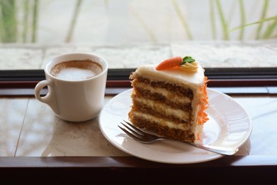 Photo of Delicious cake and cup of hot coffee on windowsill indoors