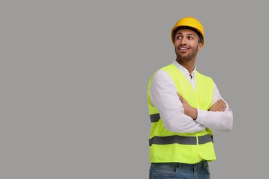 Photo of Engineer in hard hat on grey background, space for text