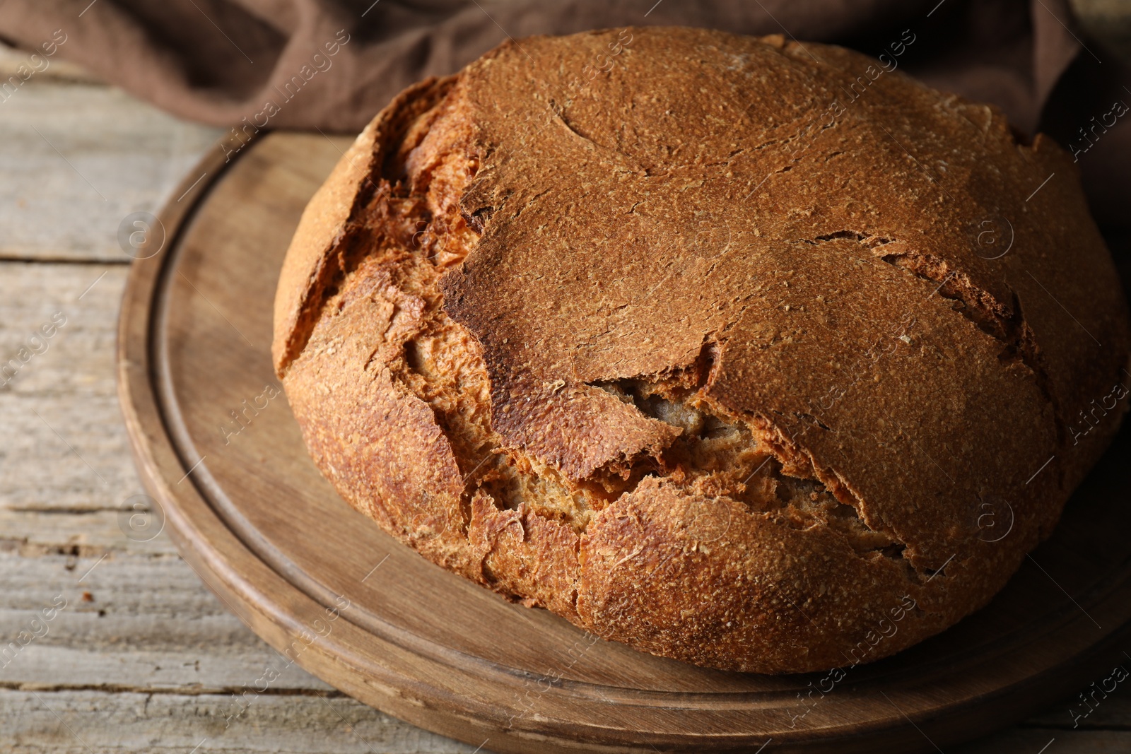 Photo of Freshly baked sourdough bread on wooden table, closeup