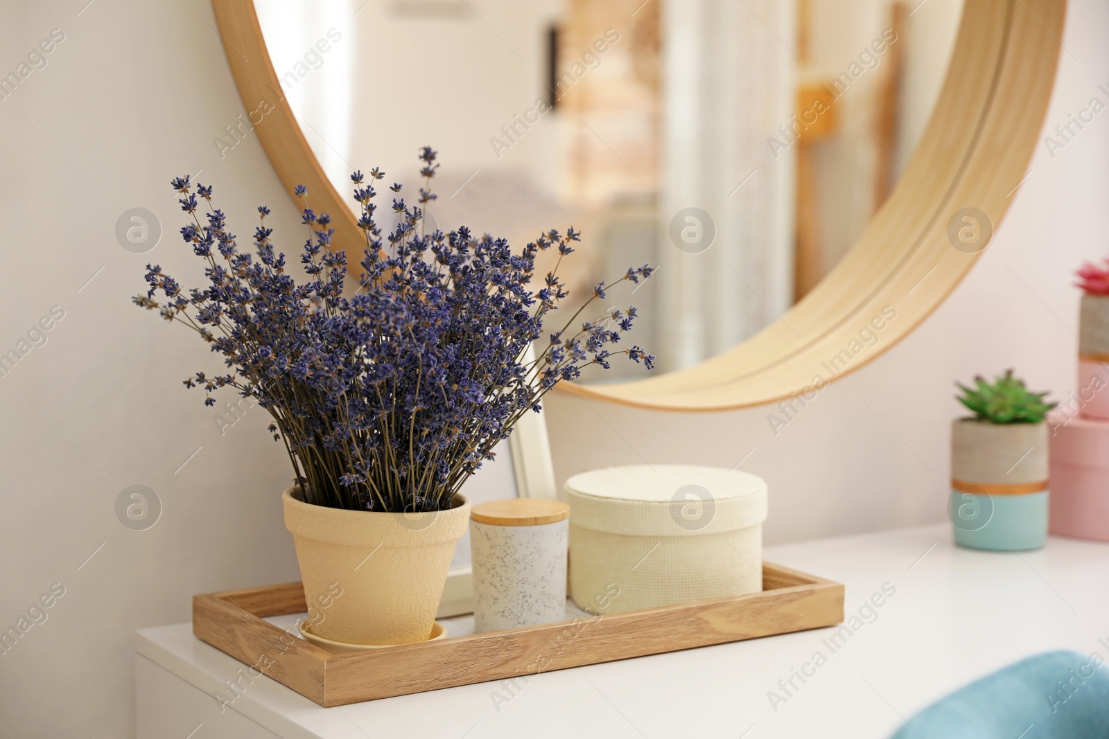 Photo of Table with beautiful lavender flowers near mirror indoors. Interior design