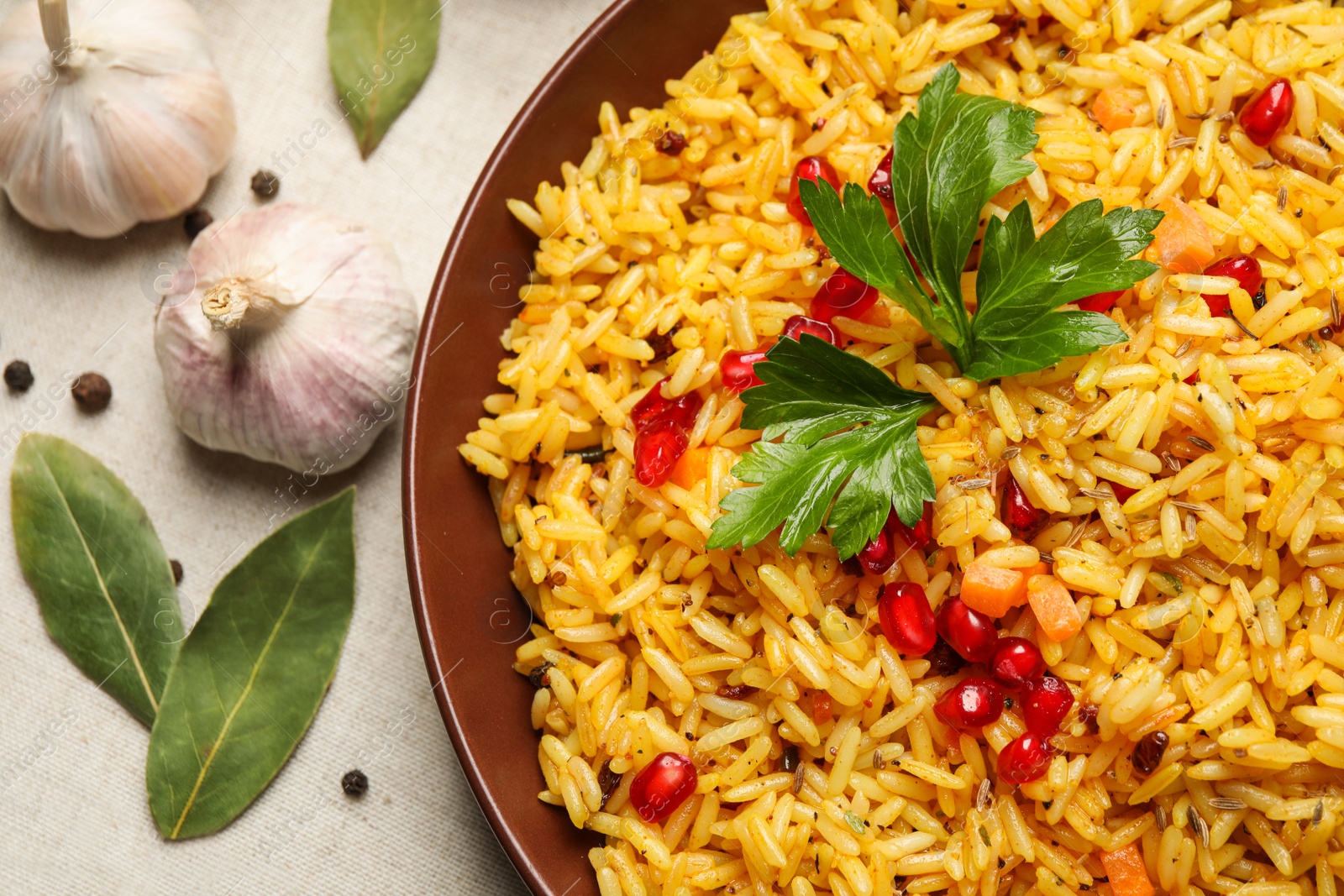 Photo of Tasty rice pilaf with pomegranate grains on table, closeup