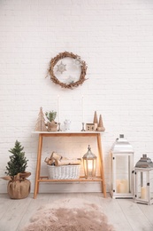 Console table with Christmas decoration near brick wall. Idea for festive interior