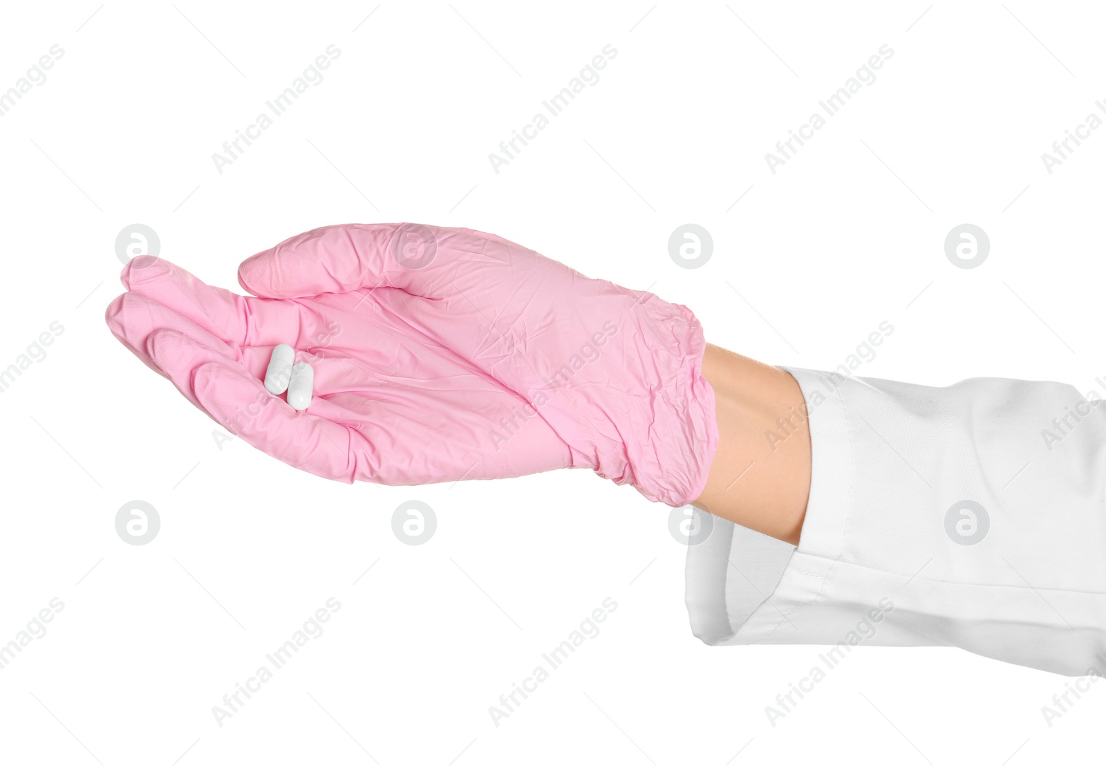 Photo of Doctor in medical glove holding pills on white background