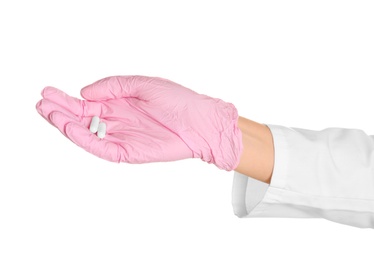 Photo of Doctor in medical glove holding pills on white background