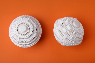 Dryer balls for washing machine on orange background, flat lay