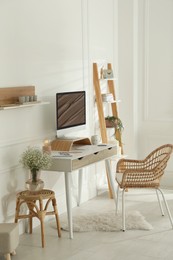 Photo of Comfortable workplace with modern computer and lamp in room. Interior design