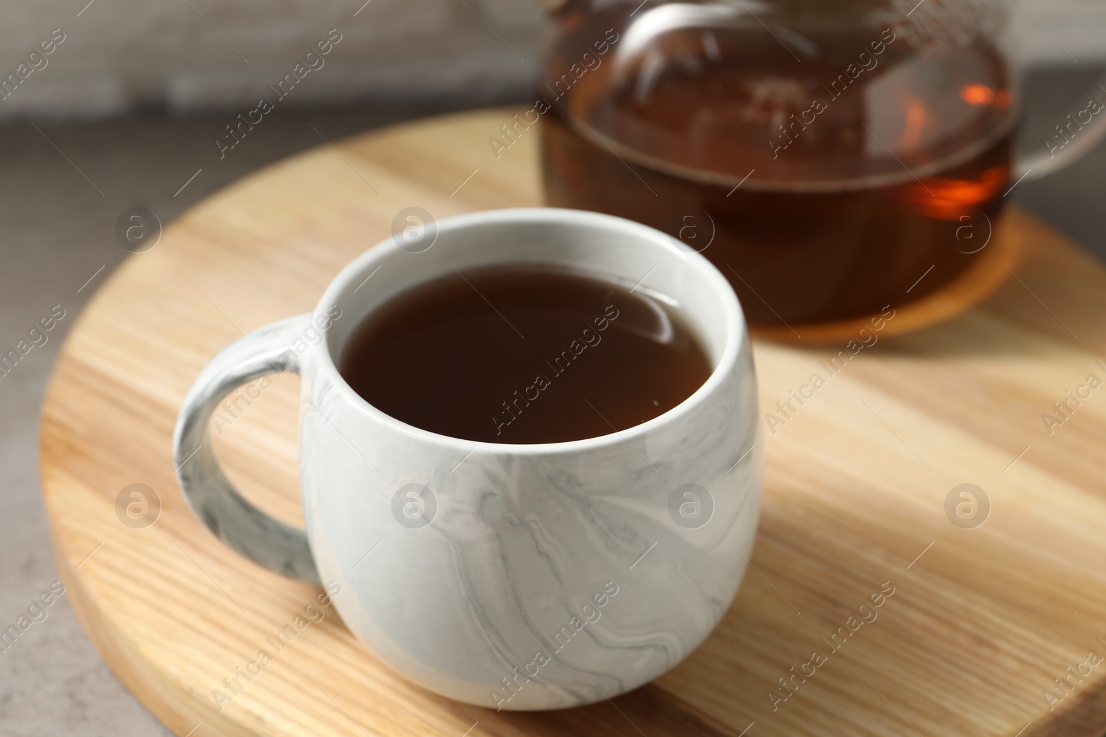 Photo of Aromatic tea in cup and glass teapot on table, closeup