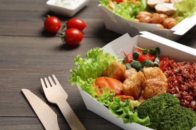 Photo of Delicious healthy meal in takeaway box on wooden table, closeup. Food delivery