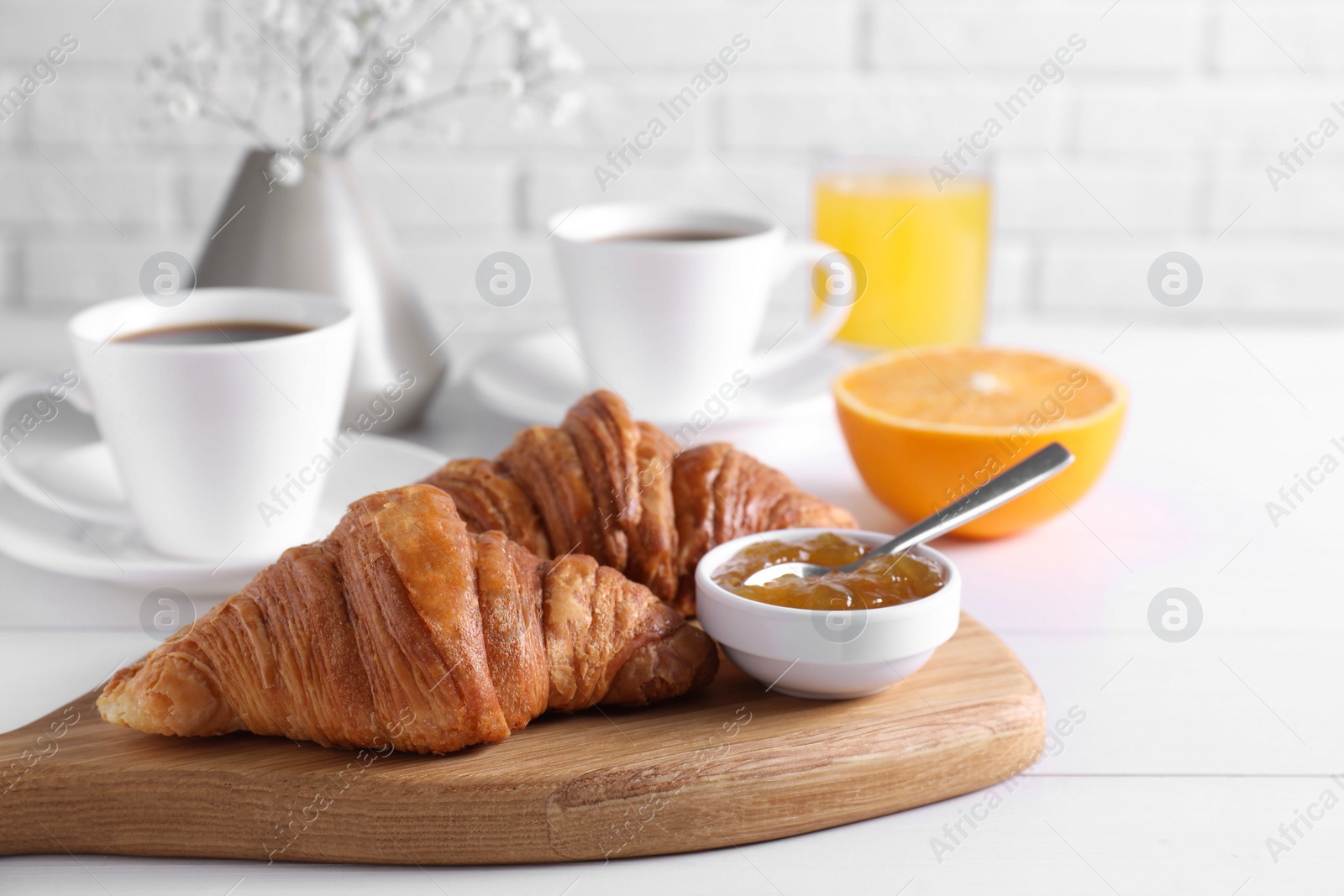 Photo of Croissants and jam on white wooden table. Tasty breakfast