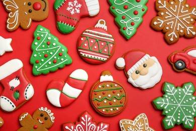 Different tasty Christmas cookies on red background, flat lay