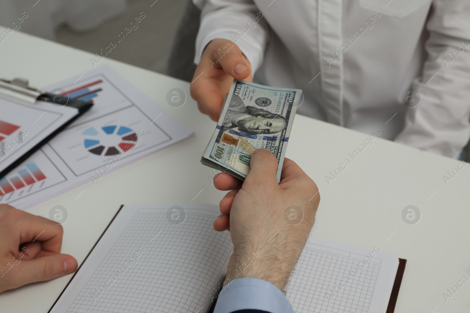 Photo of Cashier giving money to businesswoman at desk in bank, closeup