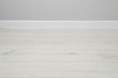 Photo of White plinth on laminated floor near wall indoors