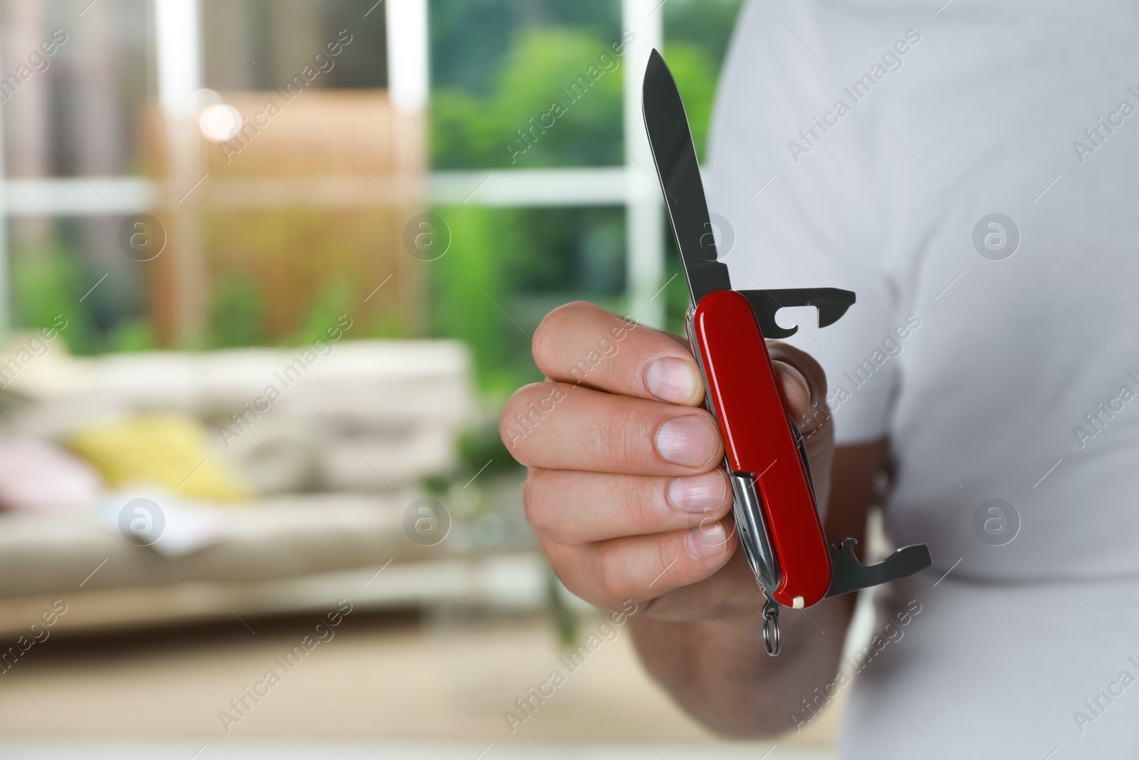 Photo of Man holding compact portable multitool indoors, closeup. Space for text