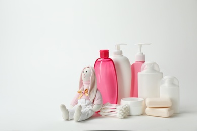 Photo of Baby cosmetic products, toy and cotton swabs on white background