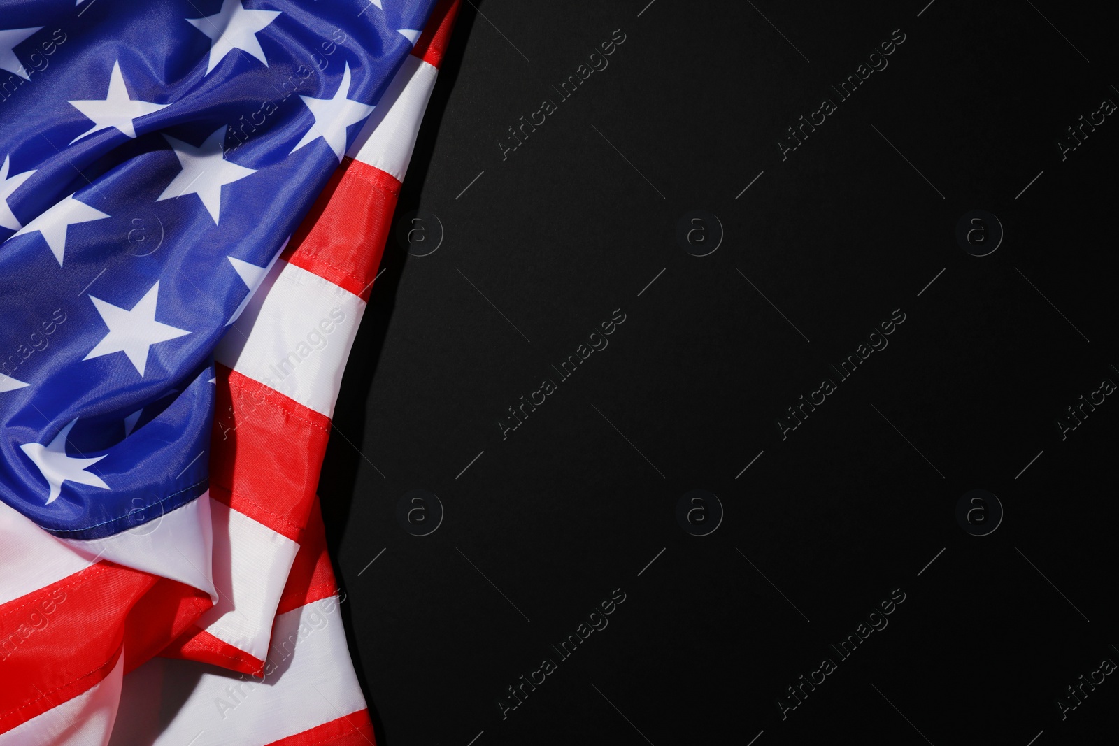 Photo of American flag on black background, top view with space for text