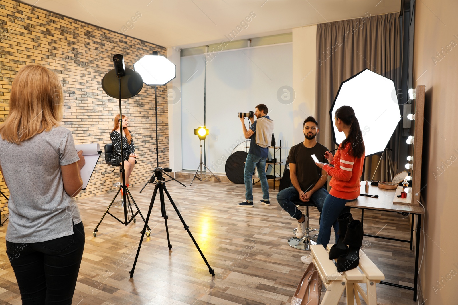 Photo of Photo studio with professional equipment and team of workers