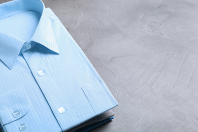 Stylish shirts on grey stone table, space for text. Dry-cleaning service