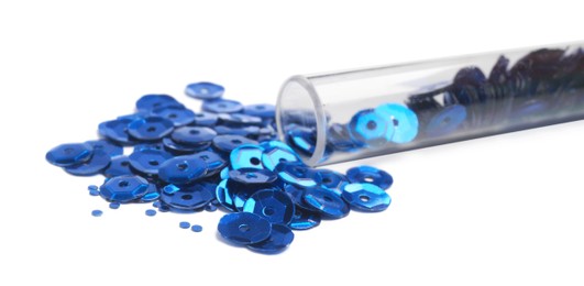 Photo of Many blue sequins and tube on white background