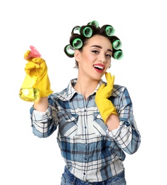 Funny young housewife with hair rollers holding detergent on white background