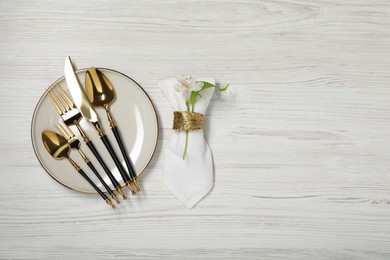 Photo of Stylish setting with elegant cutlery on white wooden table, top view. Space for text