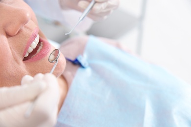 Dentist examining patient's teeth in modern clinic, closeup. Space for text