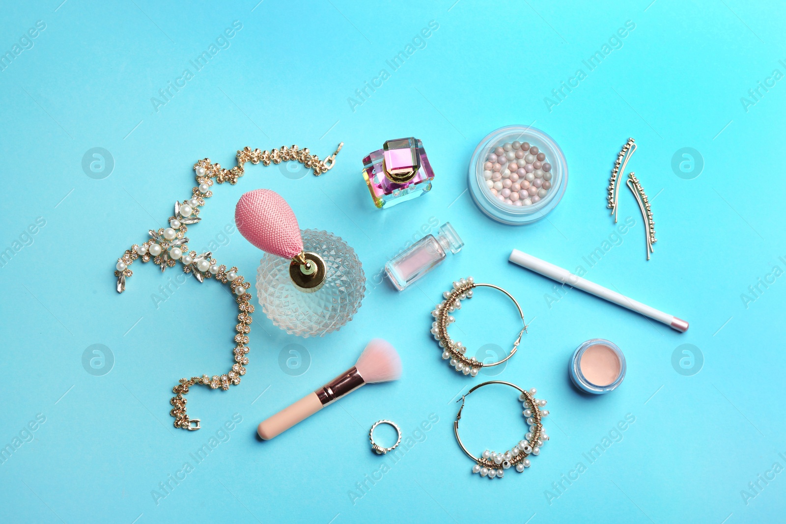 Photo of Flat lay composition with perfume bottles, jewelry and cosmetic products on blue background