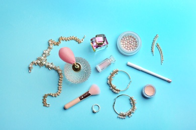 Flat lay composition with perfume bottles, jewelry and cosmetic products on blue background