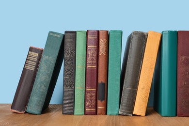 Photo of Many old hardcover books on wooden table
