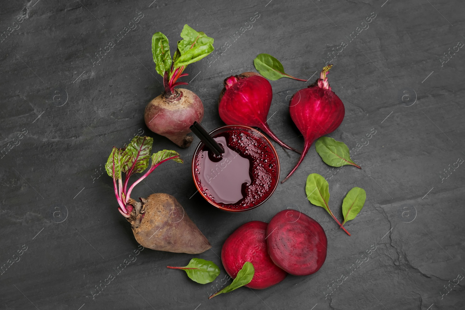 Photo of Freshly made beet juice on black table, flat lay