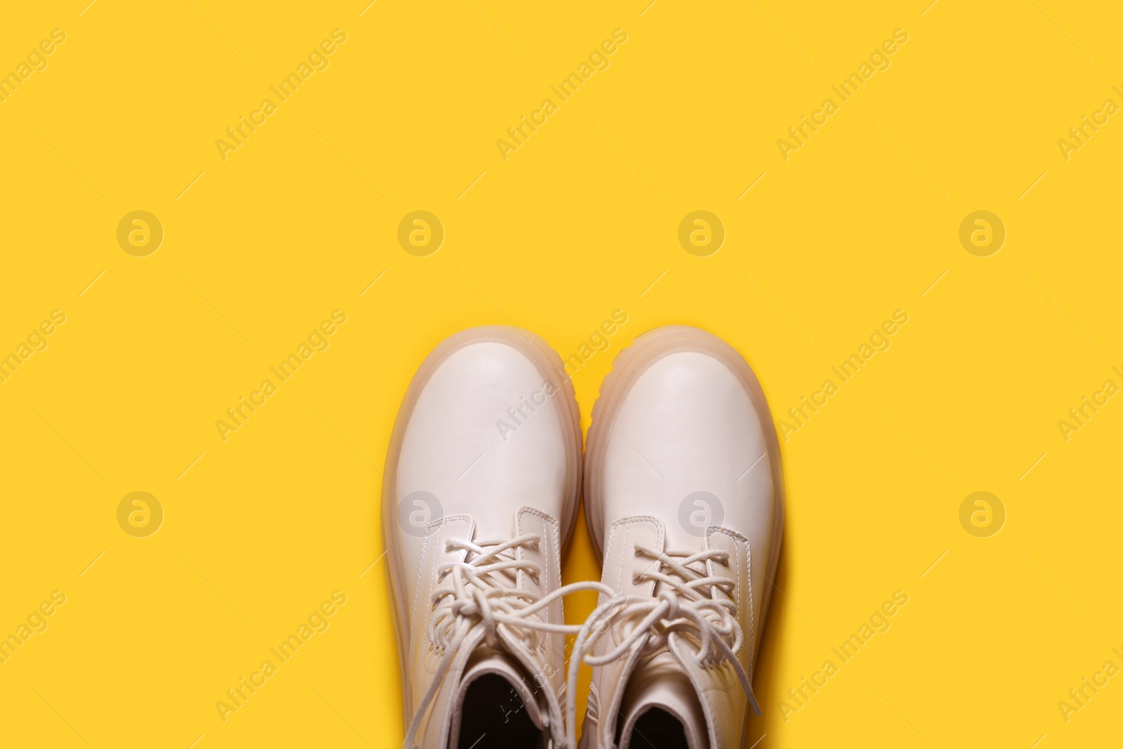 Photo of Pair of stylish leather shoes on yellow background, flat lay. Space for text