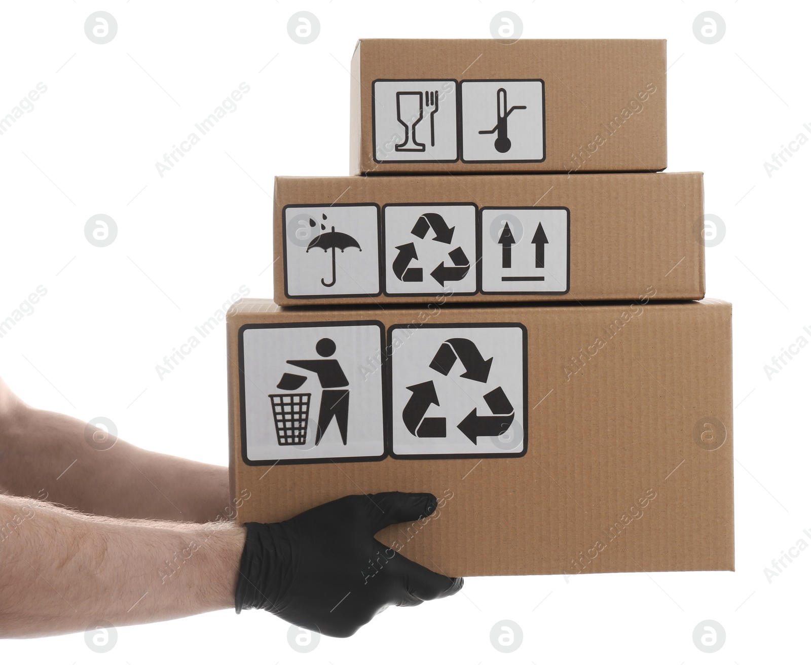 Photo of Courier holding cardboard boxes with different packaging symbols on white background, closeup. Parcel delivery